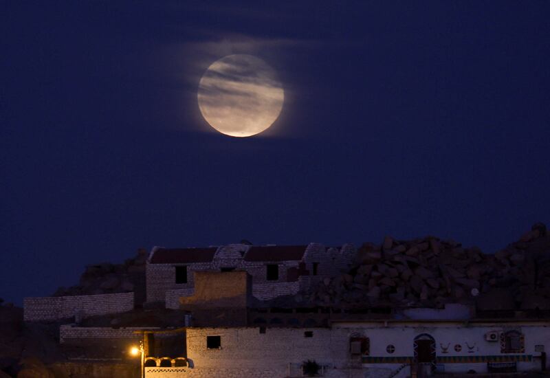La Luna Llena del Gusano se eleva sobre la isla de la aldea de Sehel en la orilla oeste del río Nilo en la ciudad egipcia meridional de Asuán.
