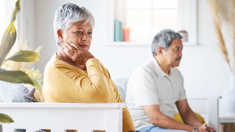 Una pareja de adultos mayores sentados en un sillón.